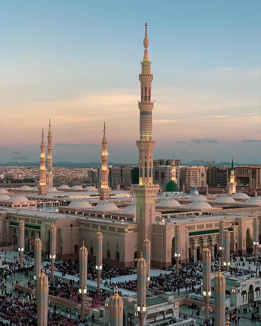 Nabawi Mosque in Medina at Dusk with Illuminated Minarets and Crowded Courtyard HD phone wallpaper