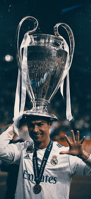 Cristiano Ronaldo lifting the UEFA Champions League trophy in a Real Madrid kit HD phone wallpaper