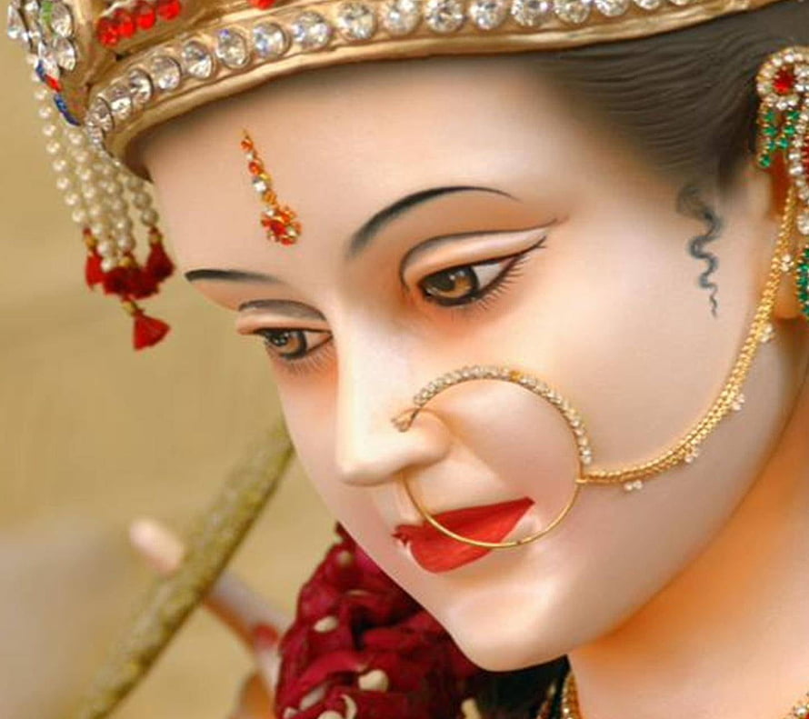 Close-up of a Maa Durga idol adorned with a jeweled crown, nose ring, and traditional Indian temple jewelry HD wallpaper