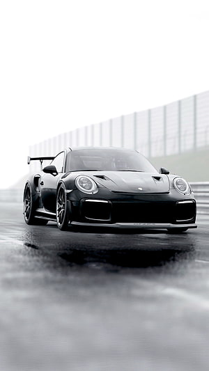 Black Porsche 911 GT3 RS on a wet racetrack with dramatic overcast lighting HD phone wallpaper