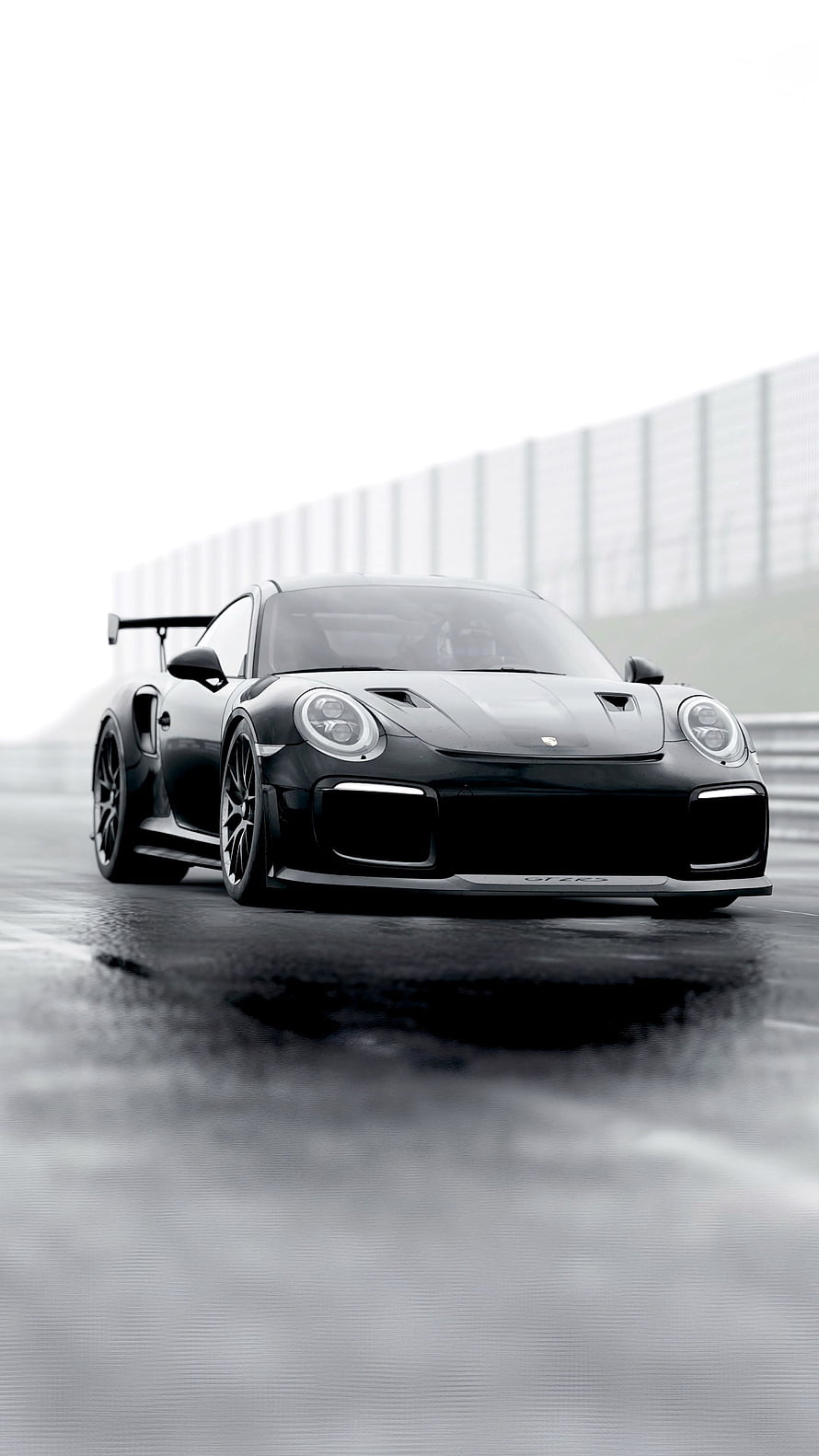 Black Porsche 911 GT3 RS on a wet racetrack with dramatic overcast lighting HD phone wallpaper
