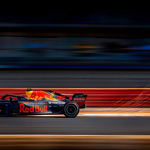 Red Bull Racing Formula 1 car speeding on track with motion blur and sparks HD phone wallpaper