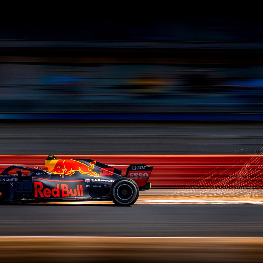 Red Bull Racing Formula 1 car speeding on track with motion blur and sparks HD phone wallpaper