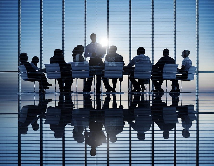 Silhouetted Business Team in Modern Conference Room with Floor Reflections HD wallpaper