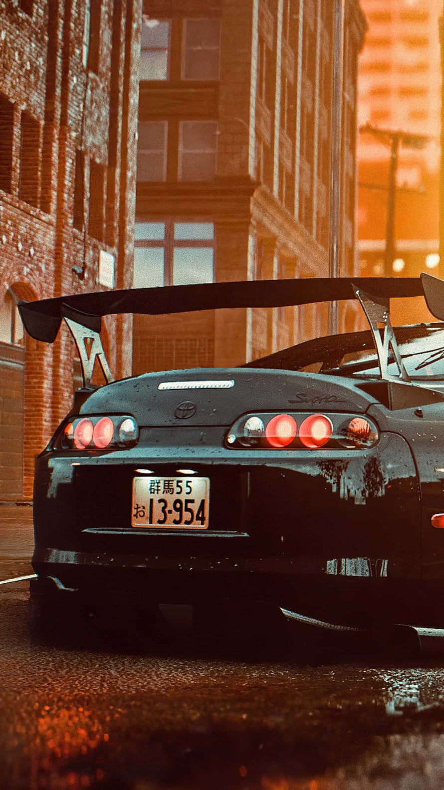 Rear View of a Black Toyota Supra with Large Rear Wing on a Wet City Street at Dusk HD phone wallpaper