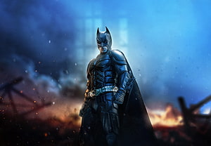 Batman in armored suit standing in a fiery blue-lit battlefield with smoke and embers HD wallpaper