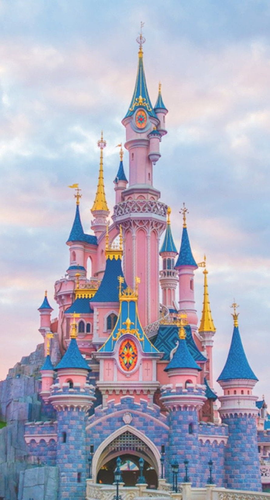 Sleeping Beauty Castle at Disneyland Park with pink turrets and blue spires under a soft pastel sky HD phone wallpaper
