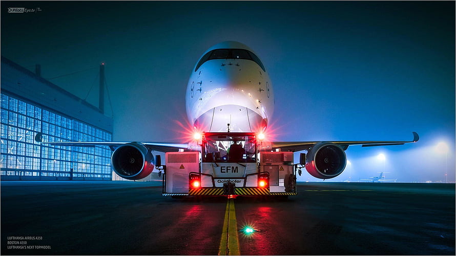 Lufthansa Airbus A350 being towed on the tarmac at night with glowing red lights HD wallpaper
