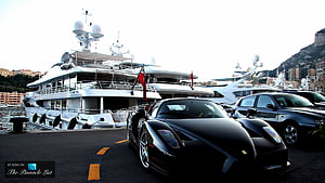 Black Ferrari Enzo Parked at Monaco Marina with Luxury Superyachts HD wallpaper