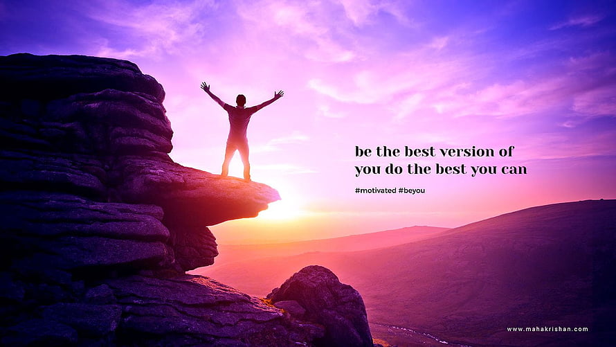 Silhouette of a person standing on a rocky cliff with arms raised against a vibrant purple and pink sunset sky HD wallpaper