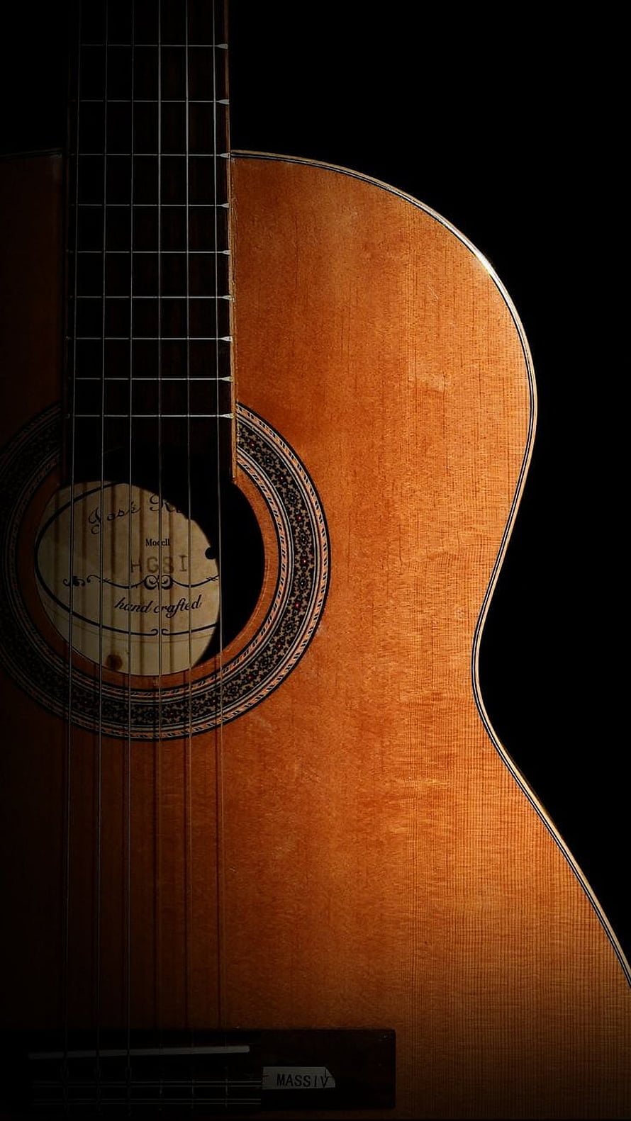 Close-up of a handcrafted acoustic guitar body with ornate rosette and warm wood grain texture HD phone wallpaper