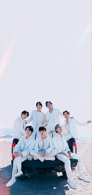 BTS Members in White Suits Posing on a Truck in a Desert Landscape HD phone wallpaper