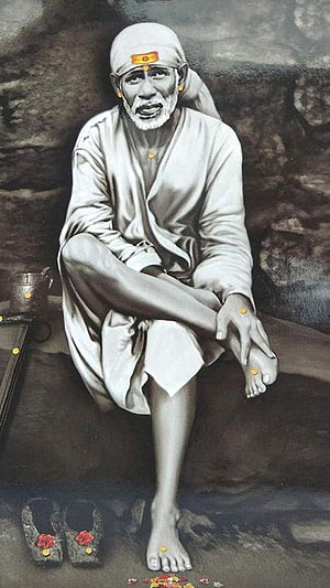 Sai Baba seated in white robes with sacred tilak marks and traditional footwear HD phone wallpaper
