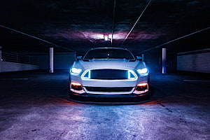 White Ford Mustang Shelby Front View in Dark Parking Garage with Neon Blue LED Grille and Headlights HD wallpaper