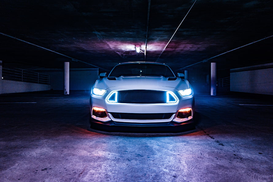 White Ford Mustang Shelby Front View in Dark Parking Garage with Neon Blue LED Grille and Headlights HD wallpaper