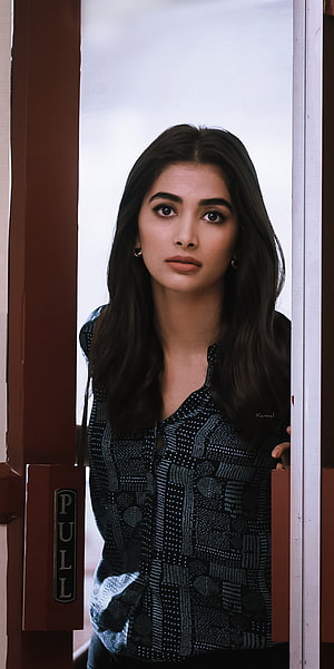 Pooja Hegde in a patterned blouse standing in a doorway with a pull sign HD phone wallpaper