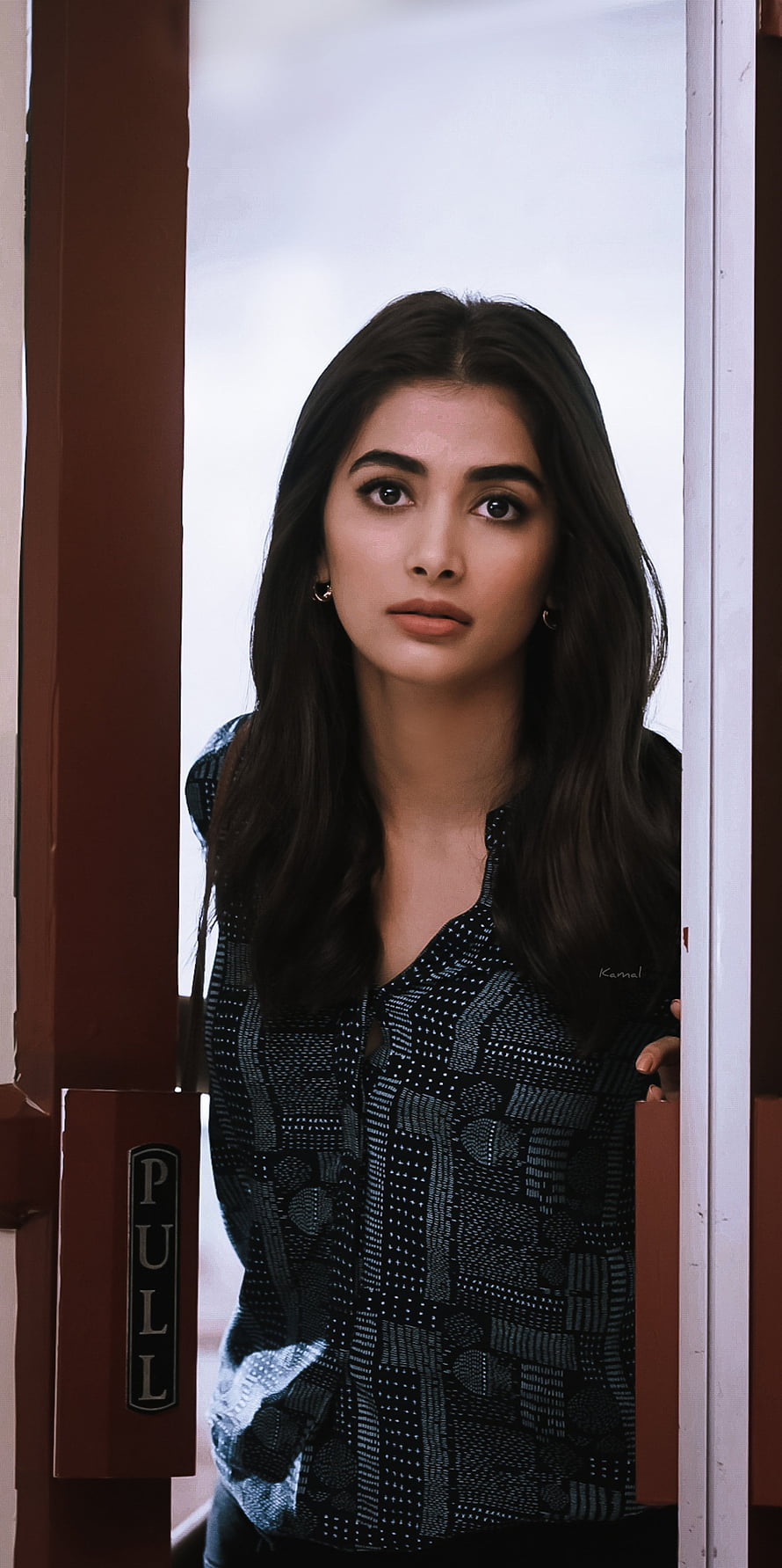 Pooja Hegde in a patterned blouse standing in a doorway with a pull sign HD phone wallpaper