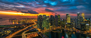 Singapore Marina Bay skyline at sunset with dramatic clouds and city lights HD wallpaper