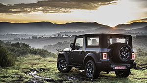 Mahindra Thar SUV parked on a misty hilltop at sunset with mountain backdrop HD wallpaper