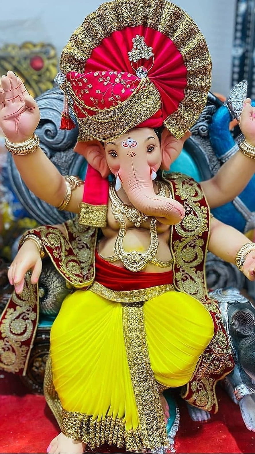 Ornate Ganesha Murti in Traditional Red and Yellow Attire with Gold Jewelry HD phone wallpaper
