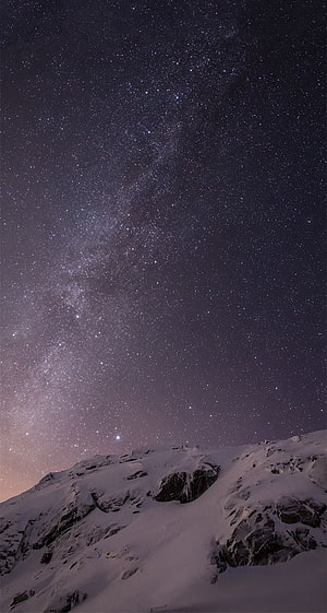 Milky Way Galaxy Arching Over Snow-Capped Mountain Peak at Night HD phone wallpaper