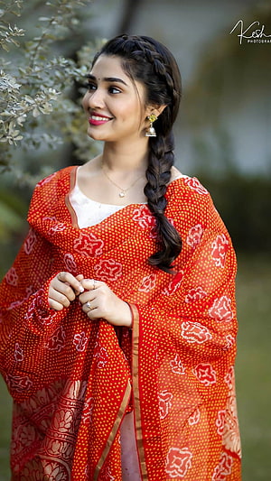 Krithi Shetty in a vibrant red Banarasi saree with a long braid and traditional jewelry HD phone wallpaper