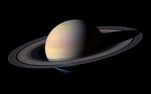 Saturn with its iconic ring system and a small moon visible against the black void of deep space HD wallpaper