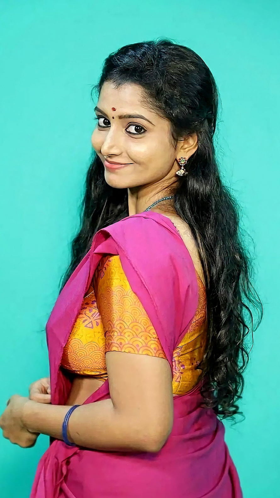 Elegant Indian woman in vibrant pink saree and gold blouse with long wavy hair HD phone wallpaper