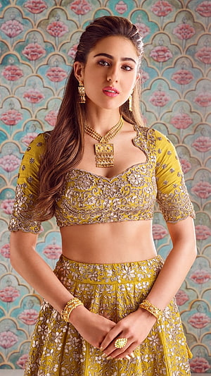 Sara Ali Khan in an ornate mustard yellow lehenga with intricate gold embroidery and traditional jewelry HD phone wallpaper