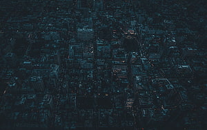 Aerial View of a Dark City at Night with Scattered Lights and Deep Blue Tones HD wallpaper