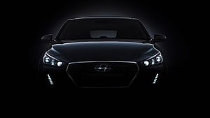 Hyundai Verna Black Front View with Illuminated Headlights and Grille in Dark Studio Setting HD wallpaper