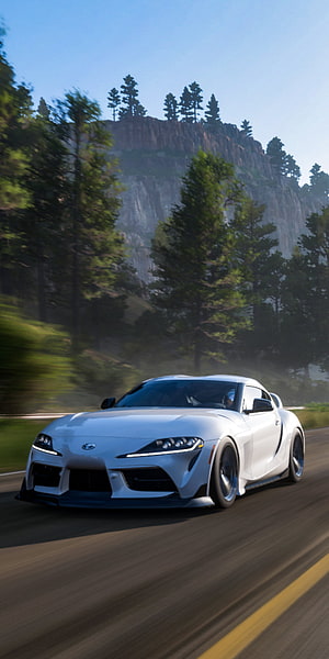White Toyota Supra speeding on a mountain road in Forza Horizon 5 HD phone wallpaper