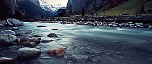 Misty Mountain River Flowing Through Rocky Valley with Snow-Capped Peaks HD wallpaper