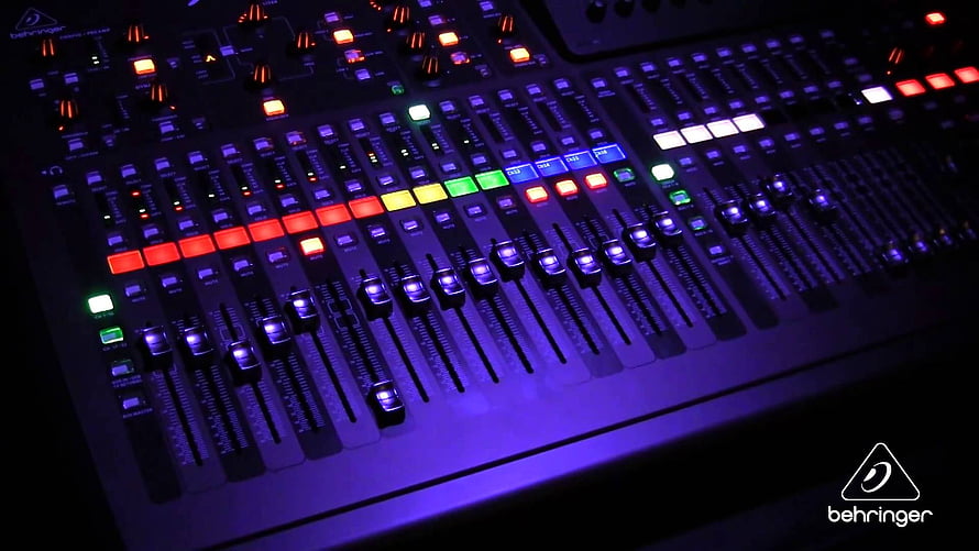 Illuminated Behringer Audio Mixing Console with Colorful Faders and Buttons in a Dark Studio Setting HD wallpaper