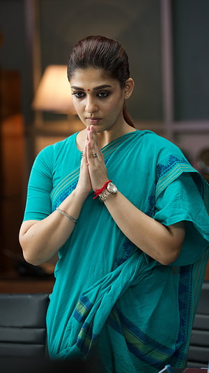 Nayanthara in a teal sari with hands pressed in a prayer gesture HD phone wallpaper