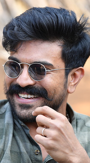 Ram Charan smiling portrait with round sunglasses and styled mustache HD phone wallpaper