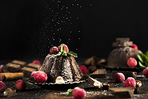 Dark Chocolate Canelé Cake Topped With Fresh Raspberries And Mint On A Black Background HD wallpaper