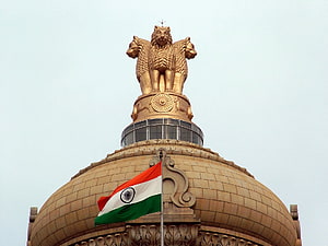 Golden Lion Capital of Ashoka atop the Indian Parliament Building with National Flag HD wallpaper