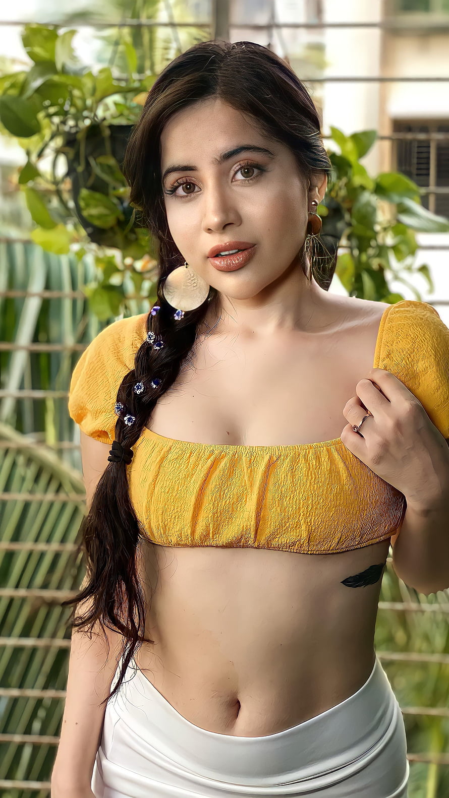 Urfi Javed in a mustard yellow crop top and white skirt with a side braid and large hoop earrings HD phone wallpaper
