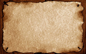 Aged Parchment Scroll with Torn Edges and Nails on Dark Wood Surface HD wallpaper