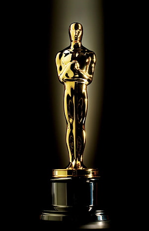 Golden Oscar Academy Award Trophy on a Reflective Black Surface HD phone wallpaper