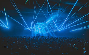 Vibrant Blue Laser Show Illuminating a Massive Concert Crowd at a Nighttime Music Festival HD wallpaper
