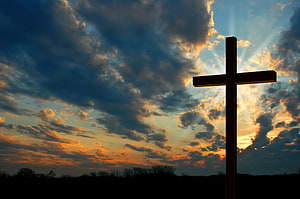 Silhouetted Christian Cross Against Dramatic Sunset Sky With Radiant Sunbeams HD wallpaper