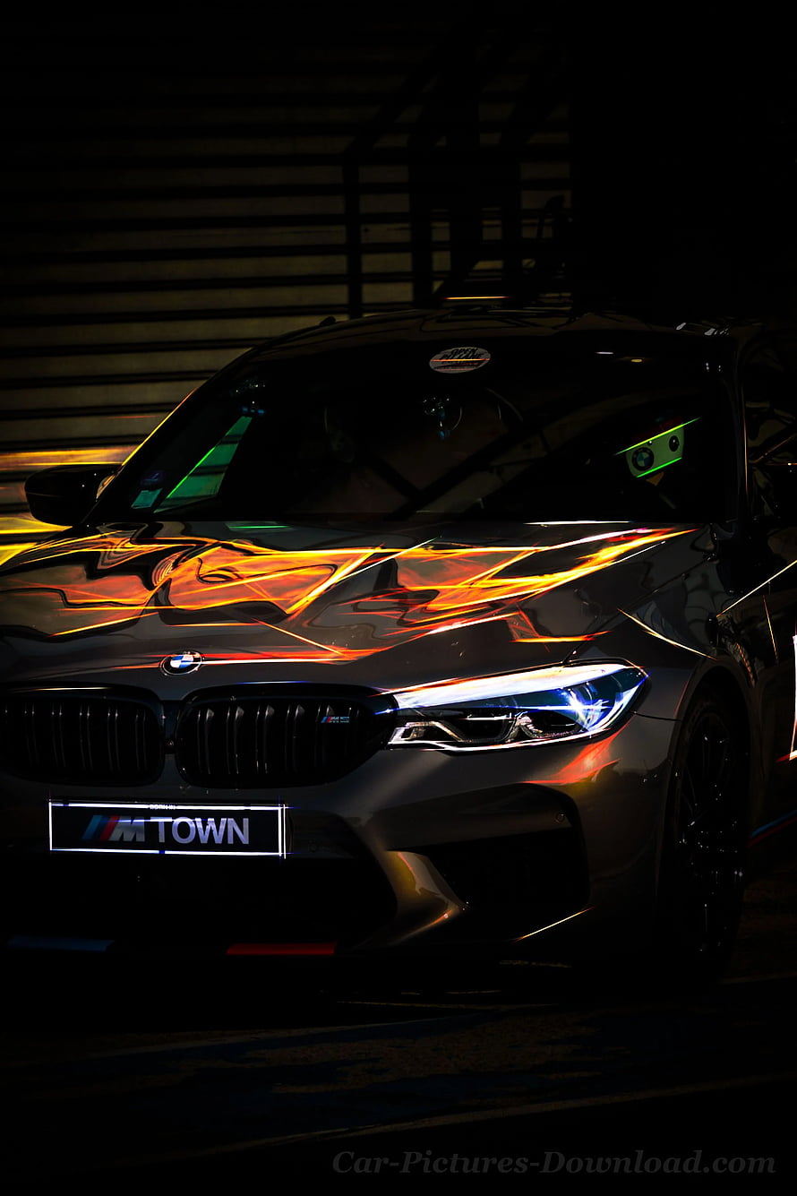 BMW M5 CS Front End with Dramatic Orange Light Reflections in Dark Setting HD phone wallpaper