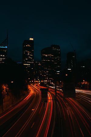 Long Exposure Night Cityscape with Highway Light Trails and Illuminated Skyscrapers HD phone wallpaper