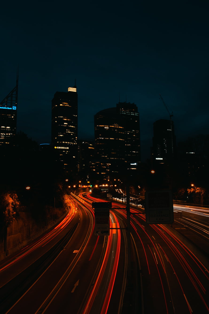 Long Exposure Night Cityscape with Highway Light Trails and Illuminated Skyscrapers HD phone wallpaper