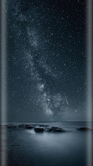Milky Way Galaxy Over a Dark Ocean Shore with Shooting Star and Rocky Coastline HD phone wallpaper