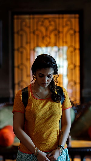 Nayantara in a yellow top and patterned skirt with a contemplative expression HD phone wallpaper