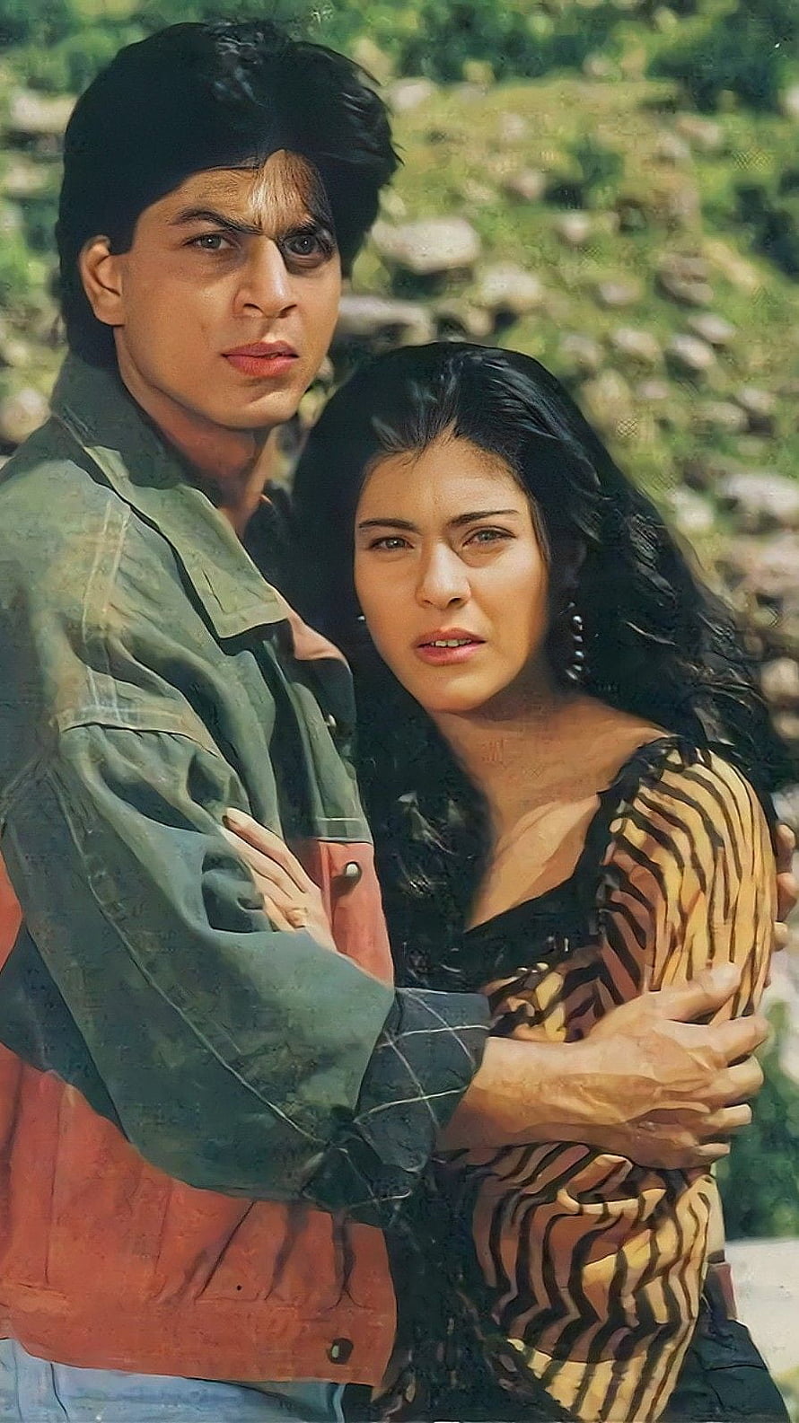 Shah Rukh Khan and Kajol in Karan Arjun, a classic Bollywood romance set against a rustic outdoor backdrop HD phone wallpaper