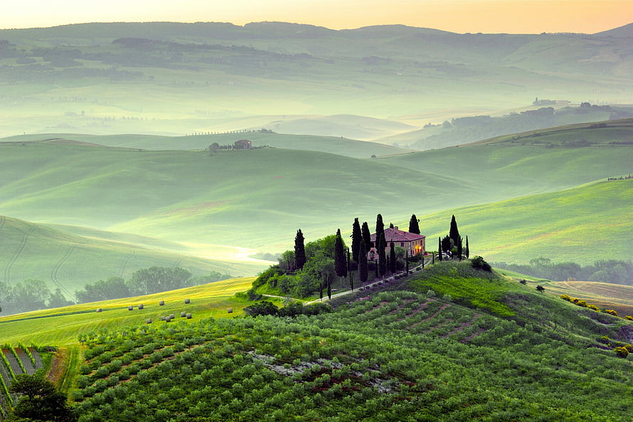Tuscan countryside at sunrise with rolling green hills, cypress trees, and a rustic villa in Tuscany, Italy HD wallpaper